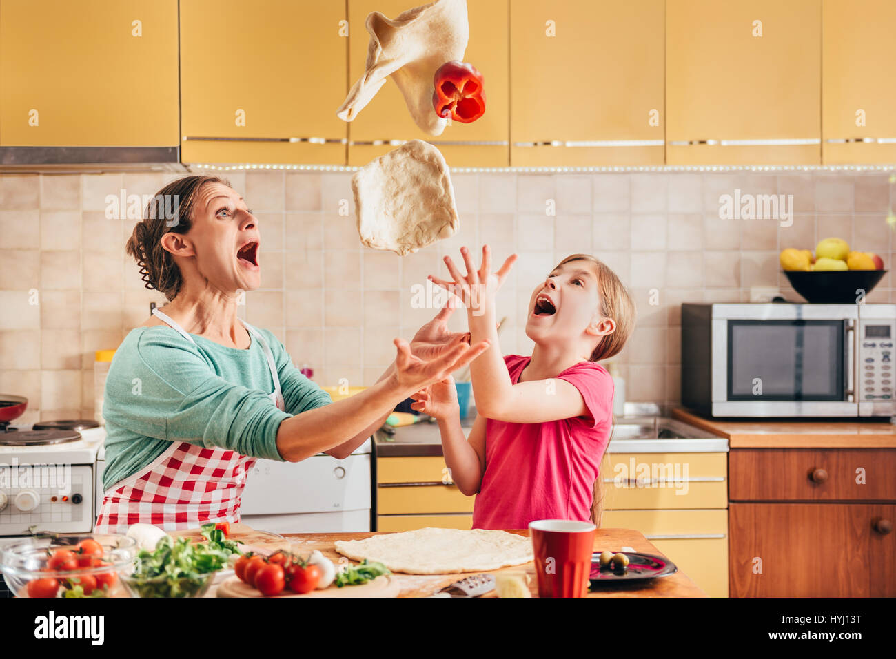 Madre e figlia preparare la pizza in cucina Foto Stock
