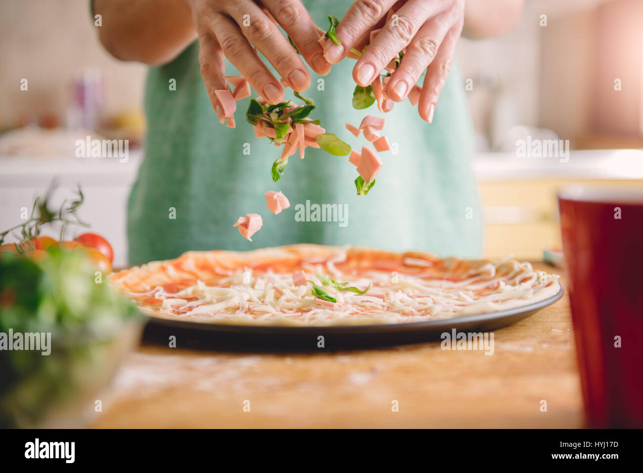Donna preparare la pizza in cucina Foto Stock