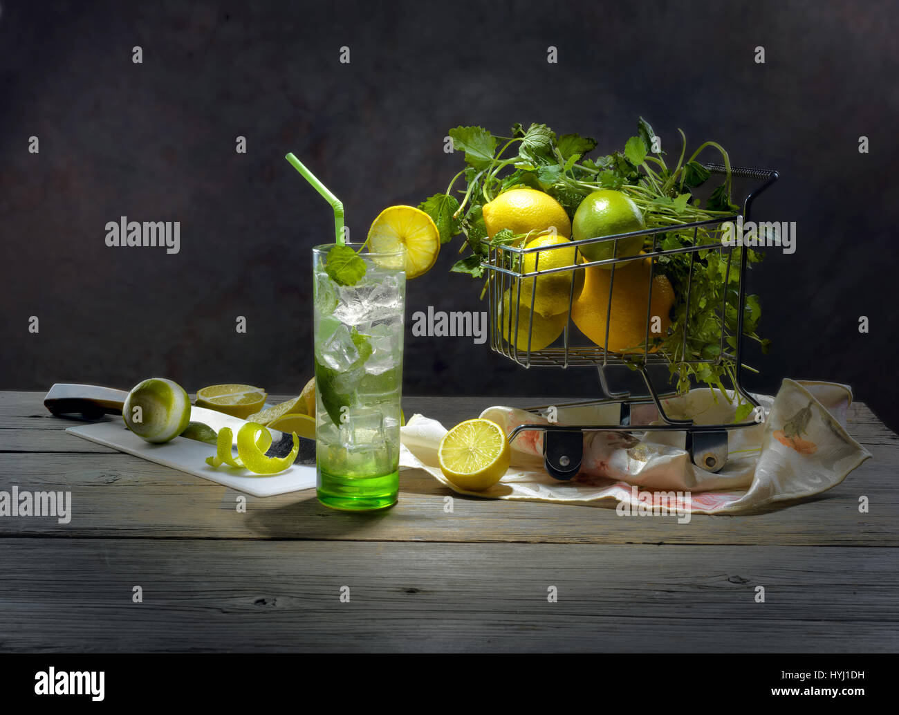 Still-life con vetro di rinfrescante cocktail mojito e agrumi su sfondo scuro Foto Stock