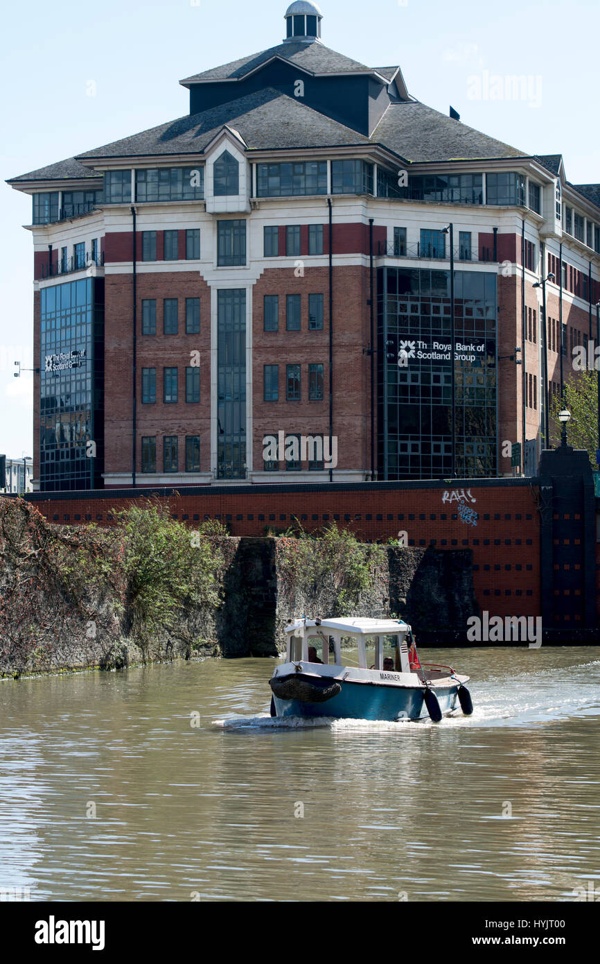 Piccola barca sul porto di galleggiante con la Royal Bank of Scotland Group edificio dietro, Bristol, Regno Unito Foto Stock