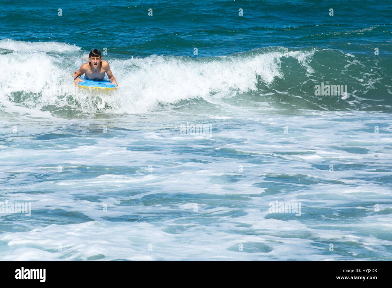 Un ragazzo surf sulle onde Foto Stock