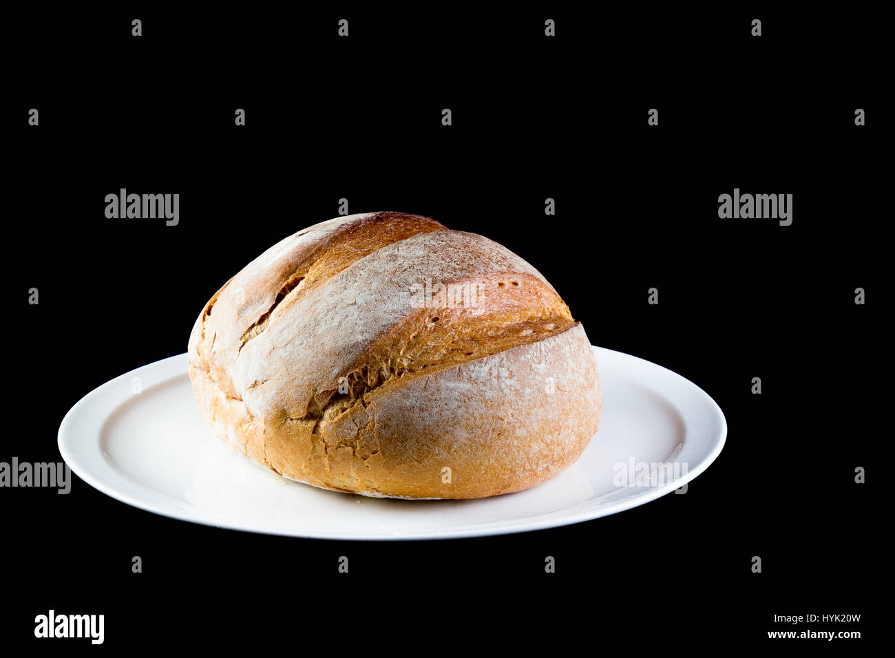 Piena medievale rustico della pagnotta di pane cotto in casa isolata su sfondo nero Foto Stock