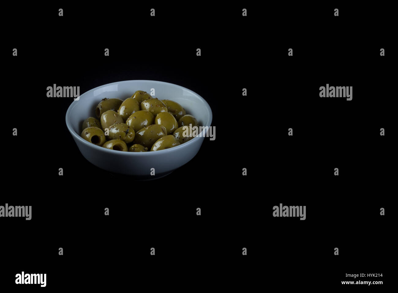 Olive molto fresco e stagionato e preparati in na ciotola bianco isolato in sfondo nero Foto Stock