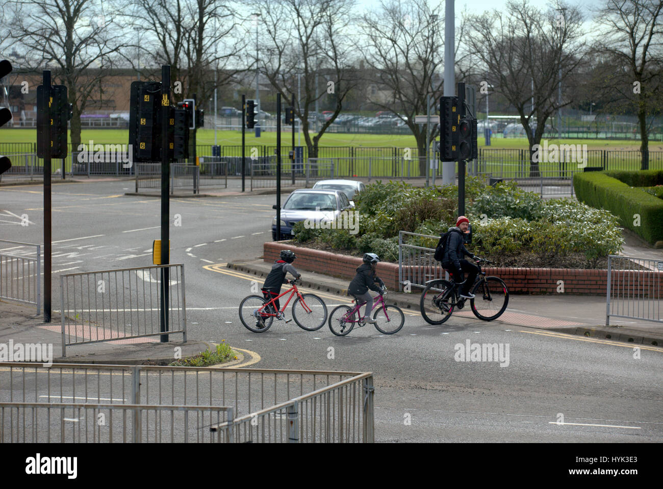 Great Western Road ciclisti padre di famiglia e bambini a croce Anniesland Glasgow Scotland street scene ad alto punto di vista Foto Stock