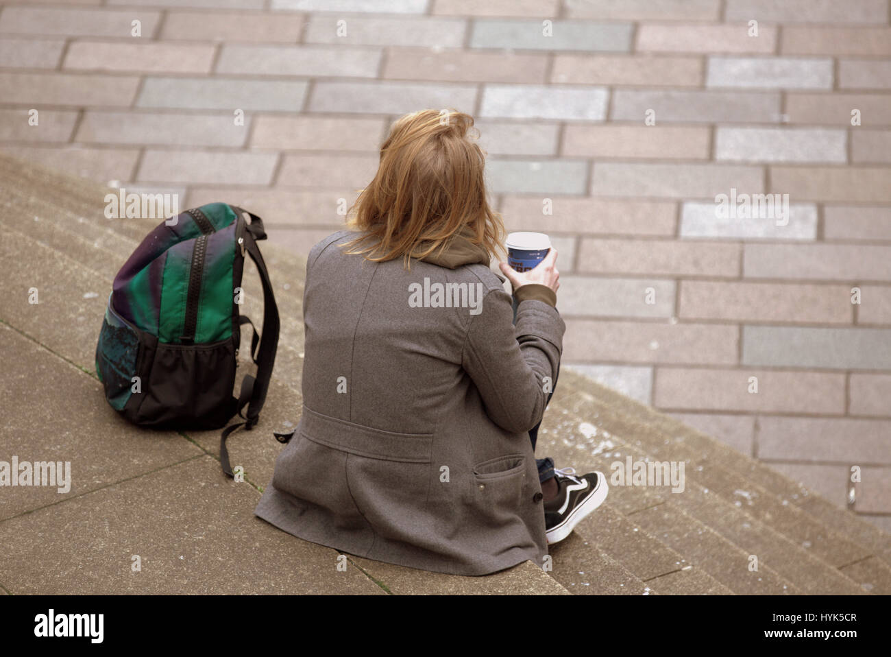 Glasgow street scene cityscape giovani turisti che si siedono sui gradini a guardare la vita dalla Foto Stock