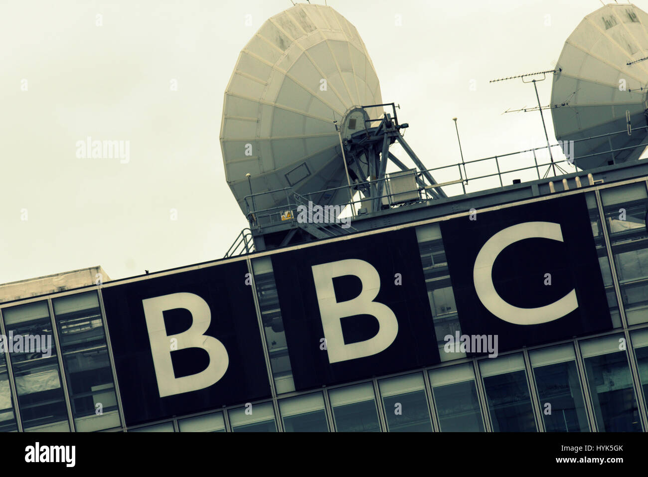 Il logo della BBC con antenne paraboliche per la ricezione satellitare Foto Stock