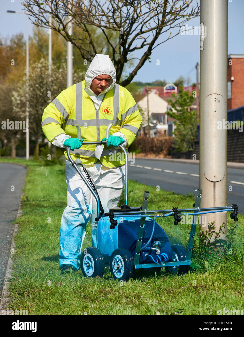 Pesticida essendo applicato alla centrale di prenotazione utilizzando una irroratrice walkover a Fabian Way Swansea. L'applicazione viene effettuata per sradicare v Foto Stock