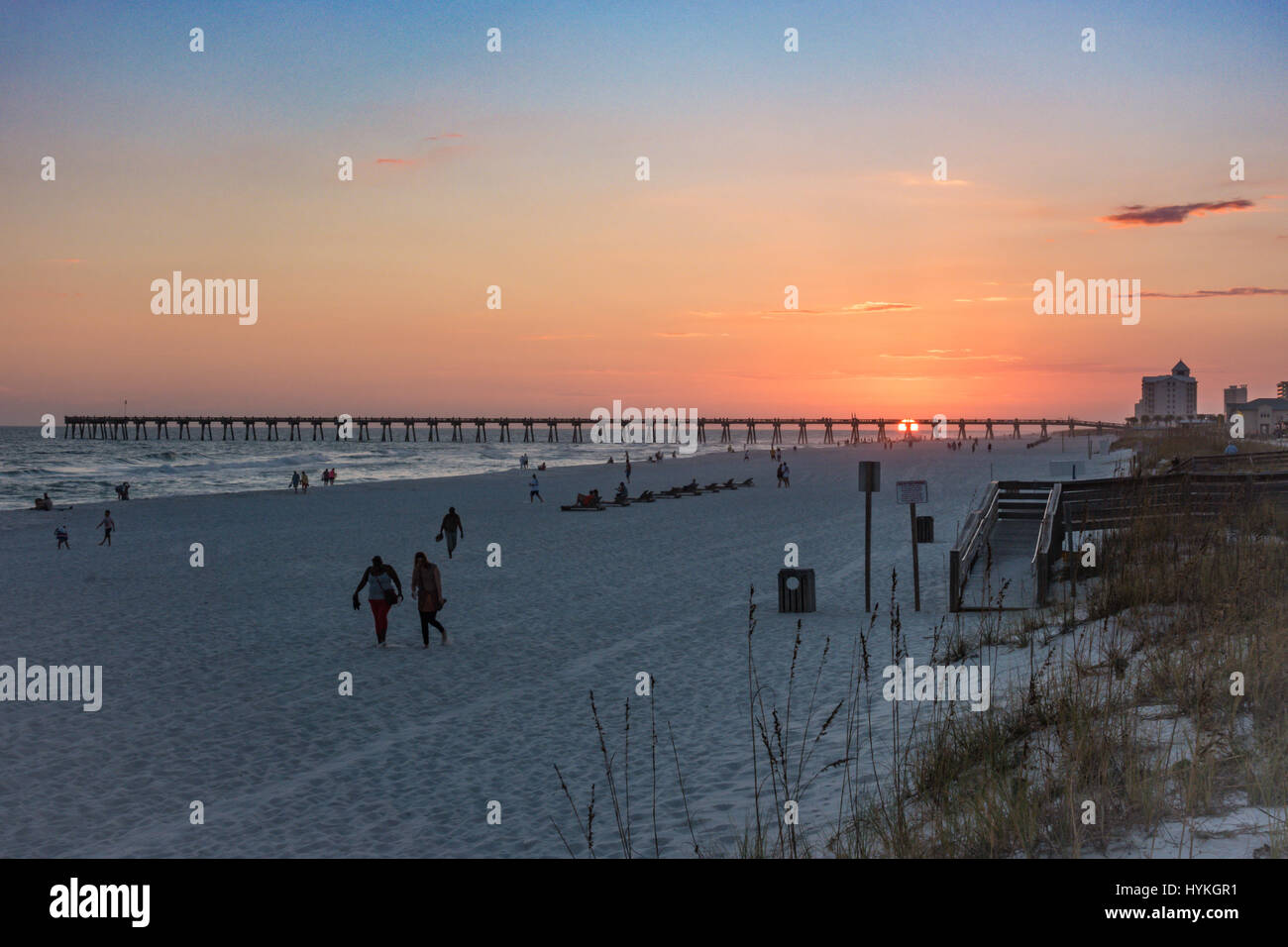 Sole che tramonta dietro al molo presso la spiaggia di Pensacola, Florida Foto Stock
