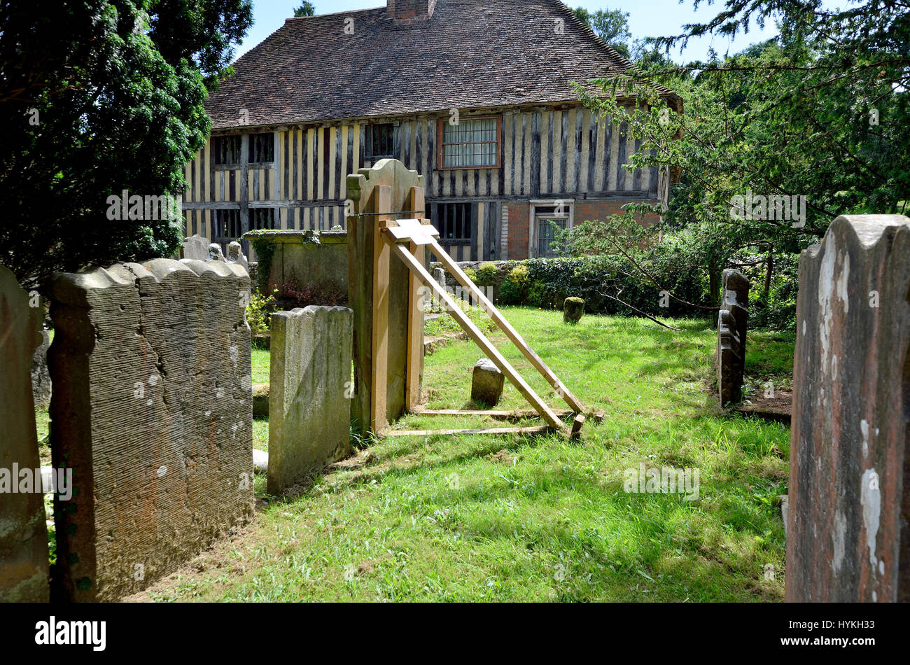 Villaggio allentati, Maidstone, Kent, Regno Unito. Pietra tombale Unsafe puntellato con un supporto in legno in tutti i Santi sagrato Foto Stock