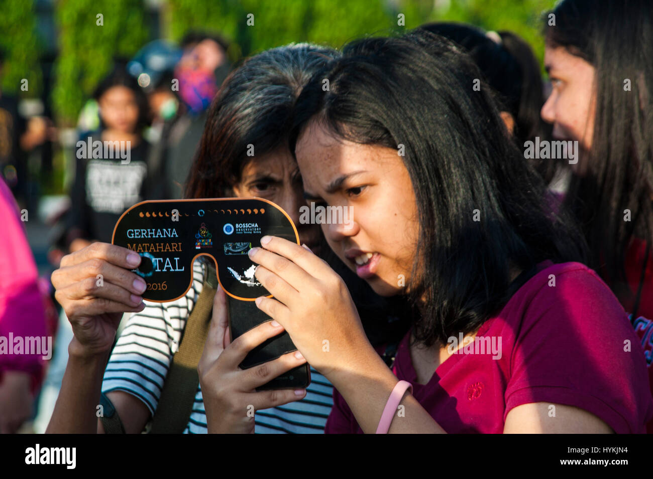 JAKARTA, Indonesia - 08 Marzo : residenti indonesiano scattare la foto di un eclissi solare con occhiali protettivi a Jakarta, Indonesia, mercoledì 9 marzo, 2016. Il raro evento astronomico è di essere testimone di mercoledì lungo uno stretto sentiero che si estende per oltre dodici province che racchiude tre fusi orari e circa 40 milioni di persone. Foto Stock