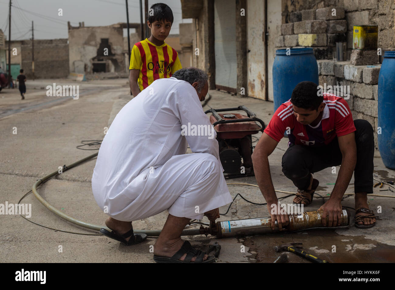MOSUL, IRAQ: un padre e figlio sta tentando di fare un sistema idraulico di pompaggio acqua per l'estrazione di acqua fresca da pozzi sotterranei, il recentemente liberato villaggi si trovano di fronte a crisi umanitaria con la mancanza di acqua potabile e di cibo. Immagini che mostrano curdo forze militari di difesa contro lo Stato islamico nei pressi di Mosul, Iraq sono state acquisite. La serie di scatti anche mostrare ciò che la vita è diventata per i civili di appena liberato villaggi vicino alla città che è ancora sotto controllo è. Altre foto mostrano i volontari il trattamento di ferite che i rifugiati che sono riusciti a fuggire di Mosul. Queste foto sono state scattate Foto Stock
