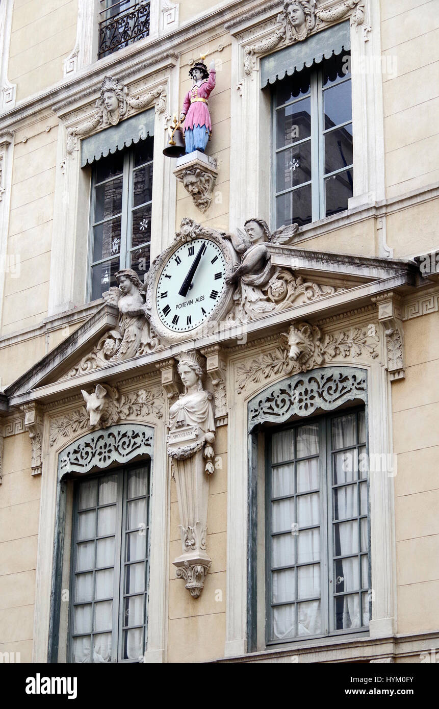 Dettaglio di elegante edificio in Place de la Hotel de Ville in Nimes, Francia, con un nero-cappello, rosa-incamiciato e trousered blu campana-suoneria. Foto Stock