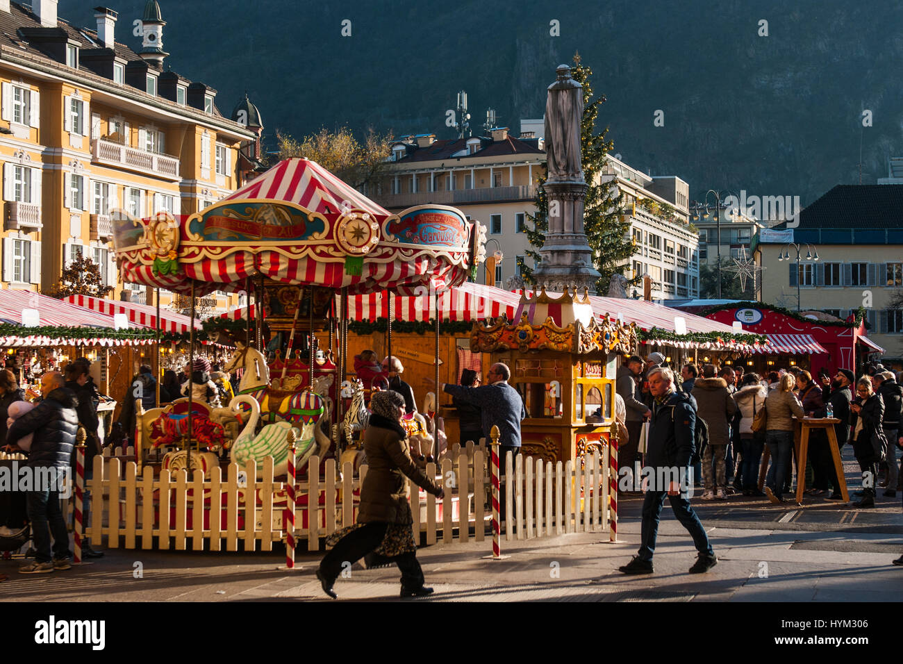 Cisitors assiste accanto a una giostra presso il tradizionale mercatino di Natale di Bolzano, in Italia. Foto Stock