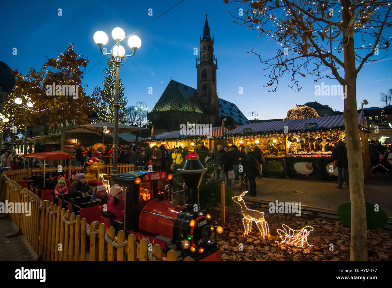 I bambini giocano in un piccolo treno presso i tradizionali mercatini di Natale di Bolzano, in Italia. Foto Stock
