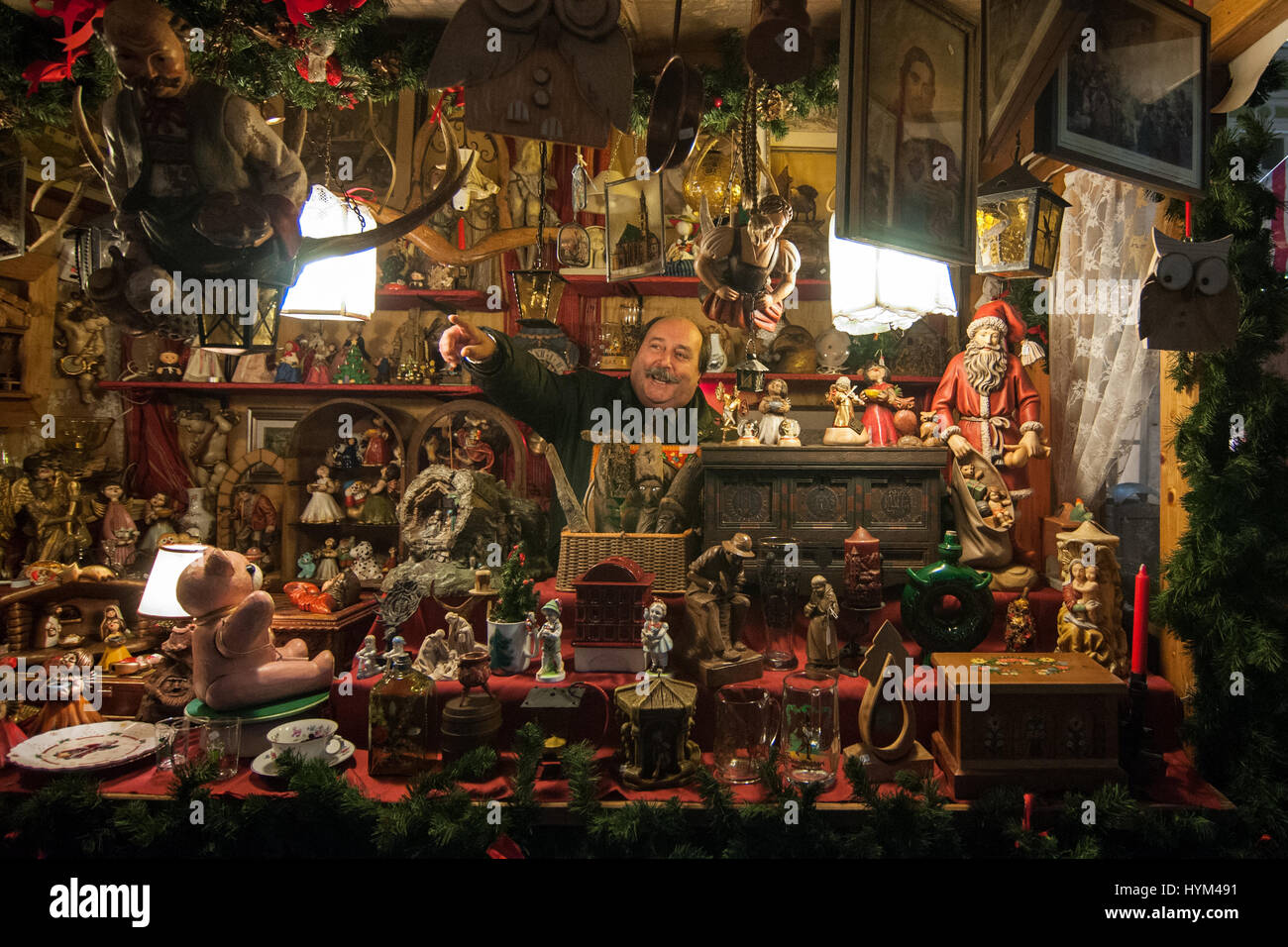 Un espositore nel suo stand di prodotti tipici presso i tradizionali mercatini di Natale di Bolzano, in Italia. Foto Stock