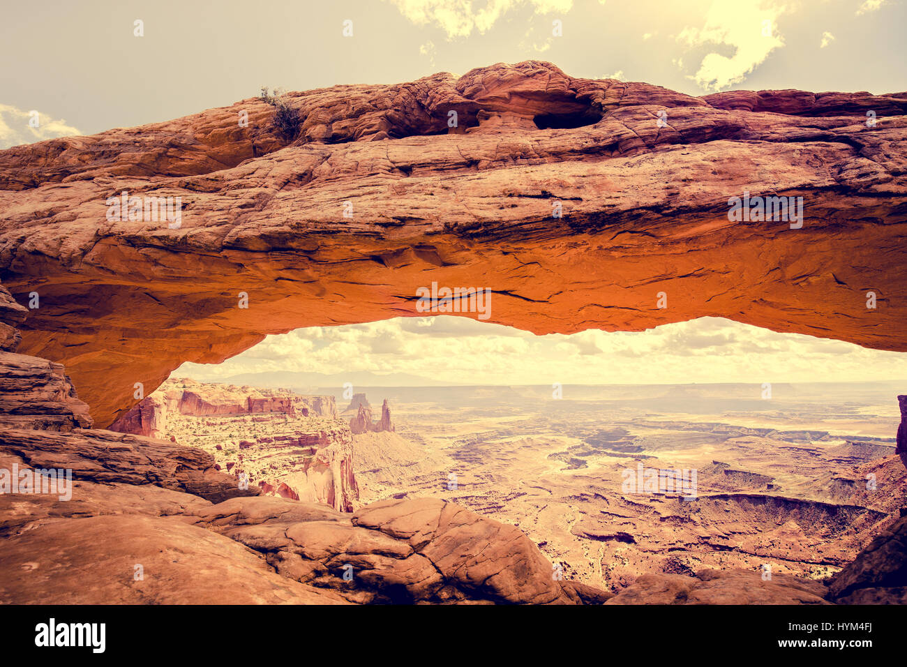 Visualizzazione classica del famoso Mesa Arch, simbolo del sud-ovest americano, illuminata a scenic golden. La luce del mattino al sorgere del sole su una bella giornata in estate Foto Stock