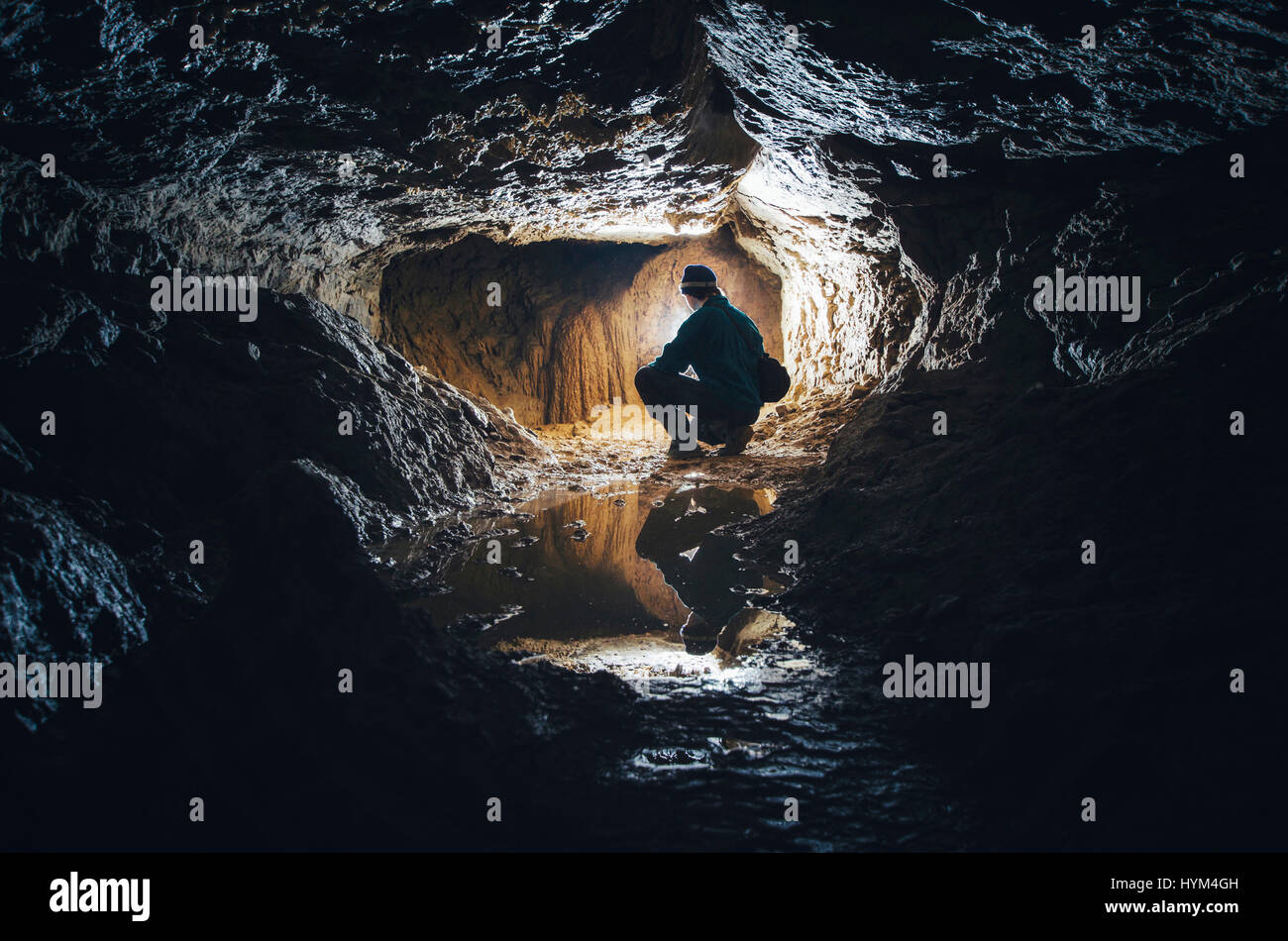 L'uomo esplorare oscura grotta di calcare tunnel paesaggio sotterraneo Foto Stock