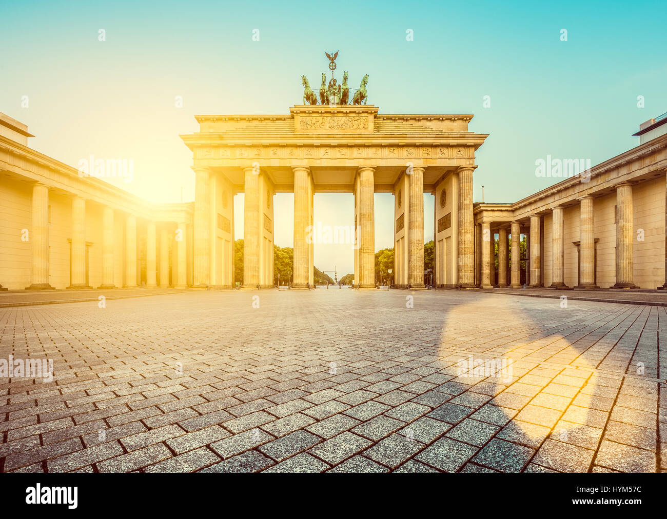 Famoso Brandenburger Tor (Porta di Brandeburgo), uno dei più noti monumenti e simboli nazionali della Germania, in beautiful Golden. La luce del mattino presso Sun Foto Stock