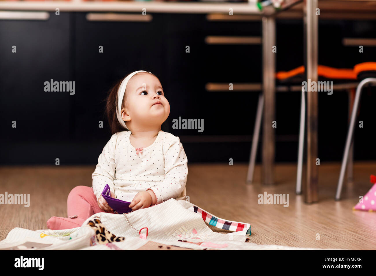Little Baby girl giocando sul pavimento della cucina. Foto Stock