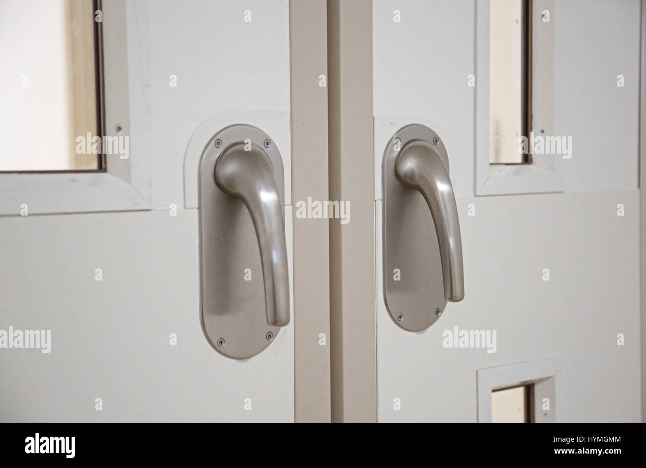 Chiusura di porte a doppio corridoio in un'unità psichiatrica residenziale sicura. Mostra le maniglie delle leve delle portiere con "bagagliaio dell'elefante" antilegatura. Foto Stock
