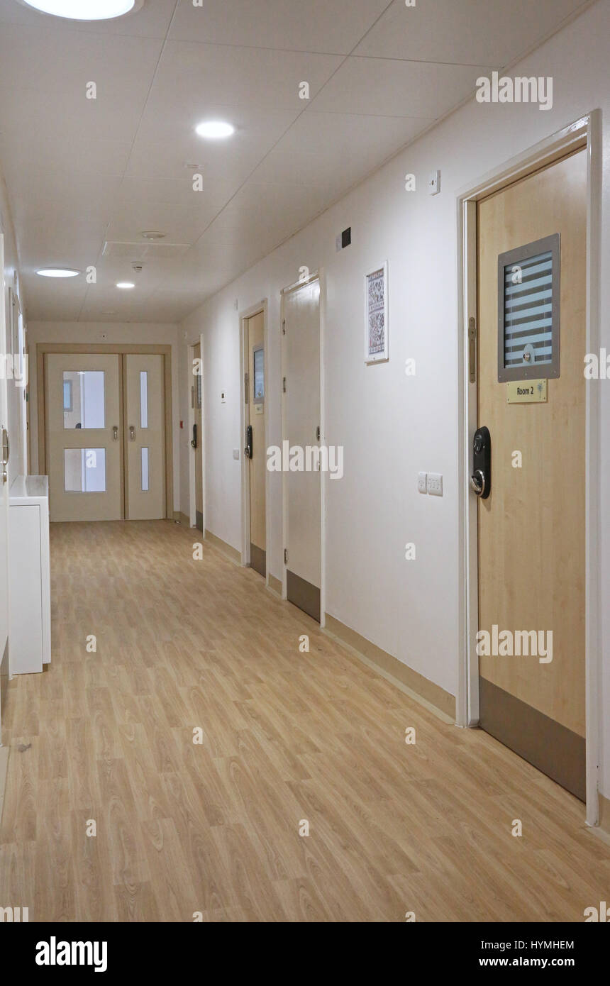Corridoio in un nuovo sicuro, residenziale unità psichiatrica. Mostra le porte camere da letto dotate di anti-legatura le maniglie della porta e bloccare il raccordo. Foto Stock