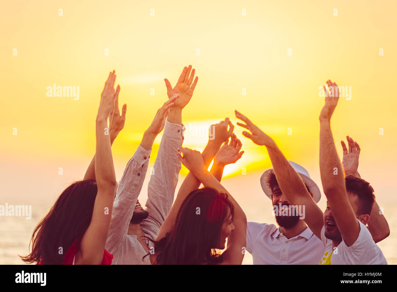 La gente ballare in spiaggia con le mani fino. concetto di partito, la musica e la gente Foto Stock