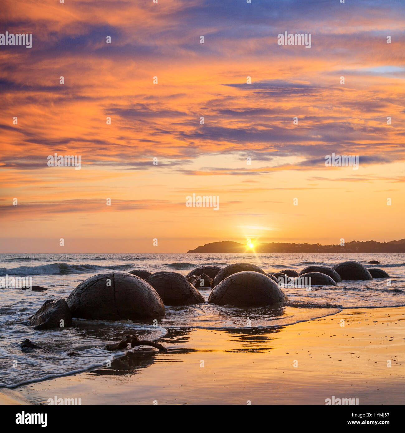 Sunrise a massi Moeraki, Otago, una grande attrazione turistica nell'Isola del Sud della Nuova Zelanda. Foto Stock