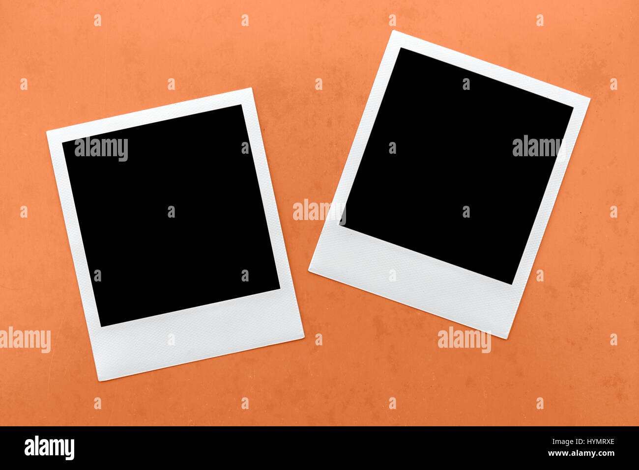 Due vuoti fotocamera istantanea fotogrammi di film su sfondo arancione. Foto Stock