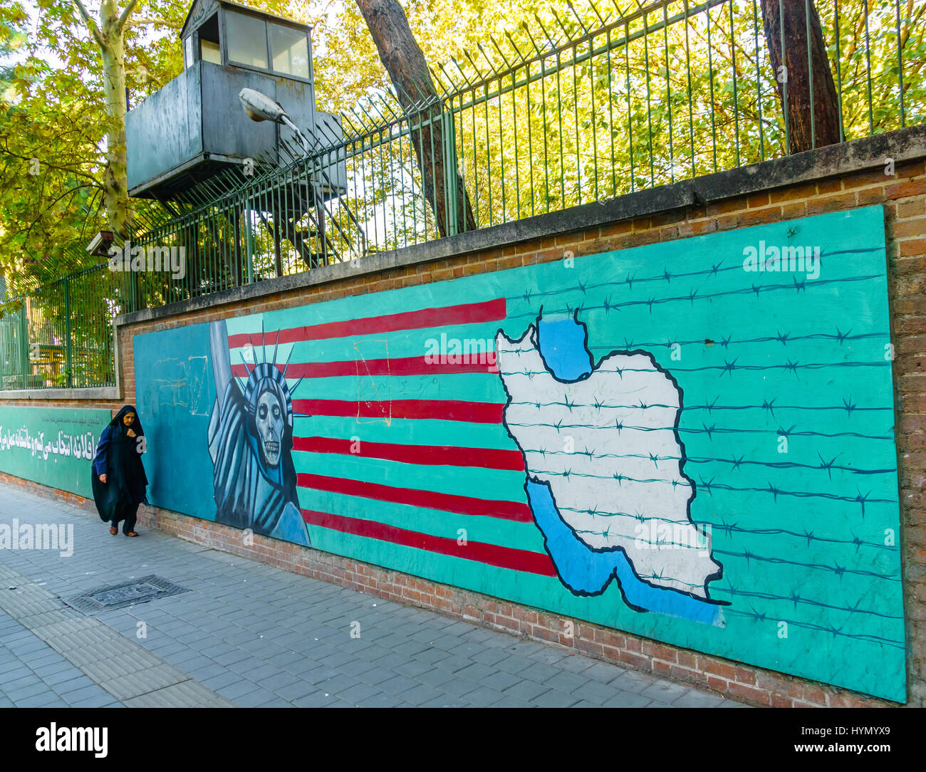 TEHERAN, IRAN - Novembre 05, 2016: propaganda iraniano murale in corrispondenza della parete della ex ambasciata degli Stati Uniti e la donna velata a Teheran Foto Stock