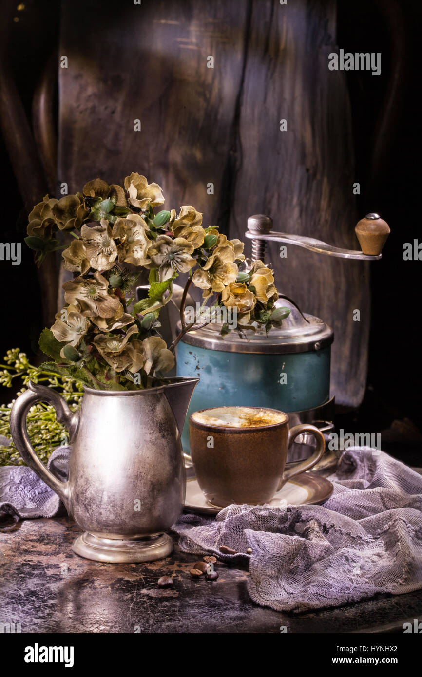 Fiori, una tazza di caffè e caffè vecchio mulino su un sfondo vintage Foto Stock