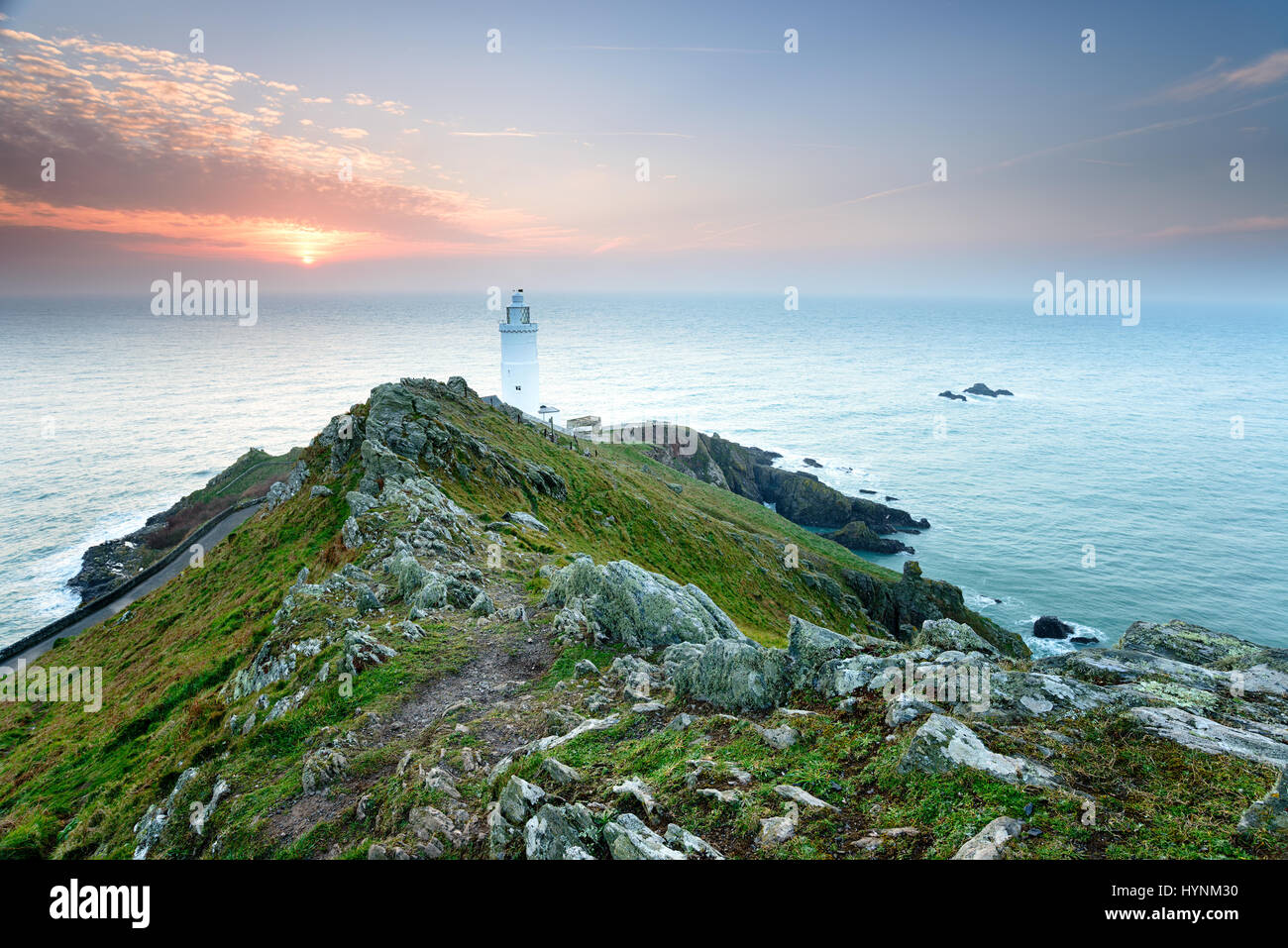 Alba sopra il faro presso il punto di partenza del Devon Coast Foto Stock