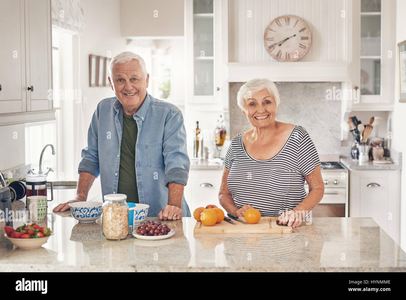 Seniors sorridente preparare una sana colazione insieme a casa Foto Stock