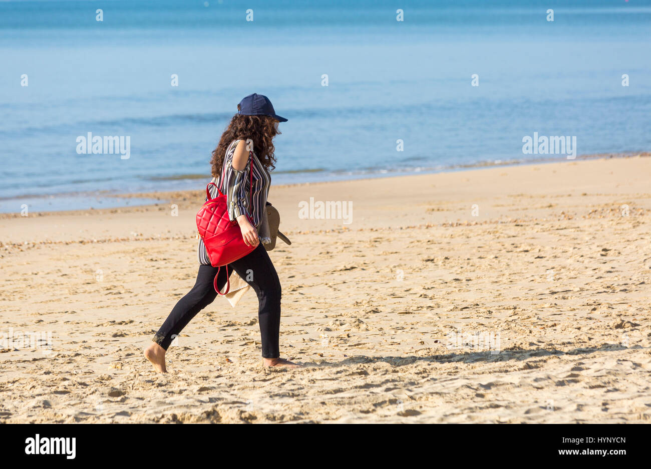 Bournemouth Dorset, Regno Unito. 6 apr, 2017. Regno Unito: meteo bella calda giornata di sole come testa di visitatori al mare per rendere la maggior parte del sole a Bournemouth spiagge. Giovane donna camminando lungo la spiaggia. Credito: Carolyn Jenkins/Alamy Live News Foto Stock