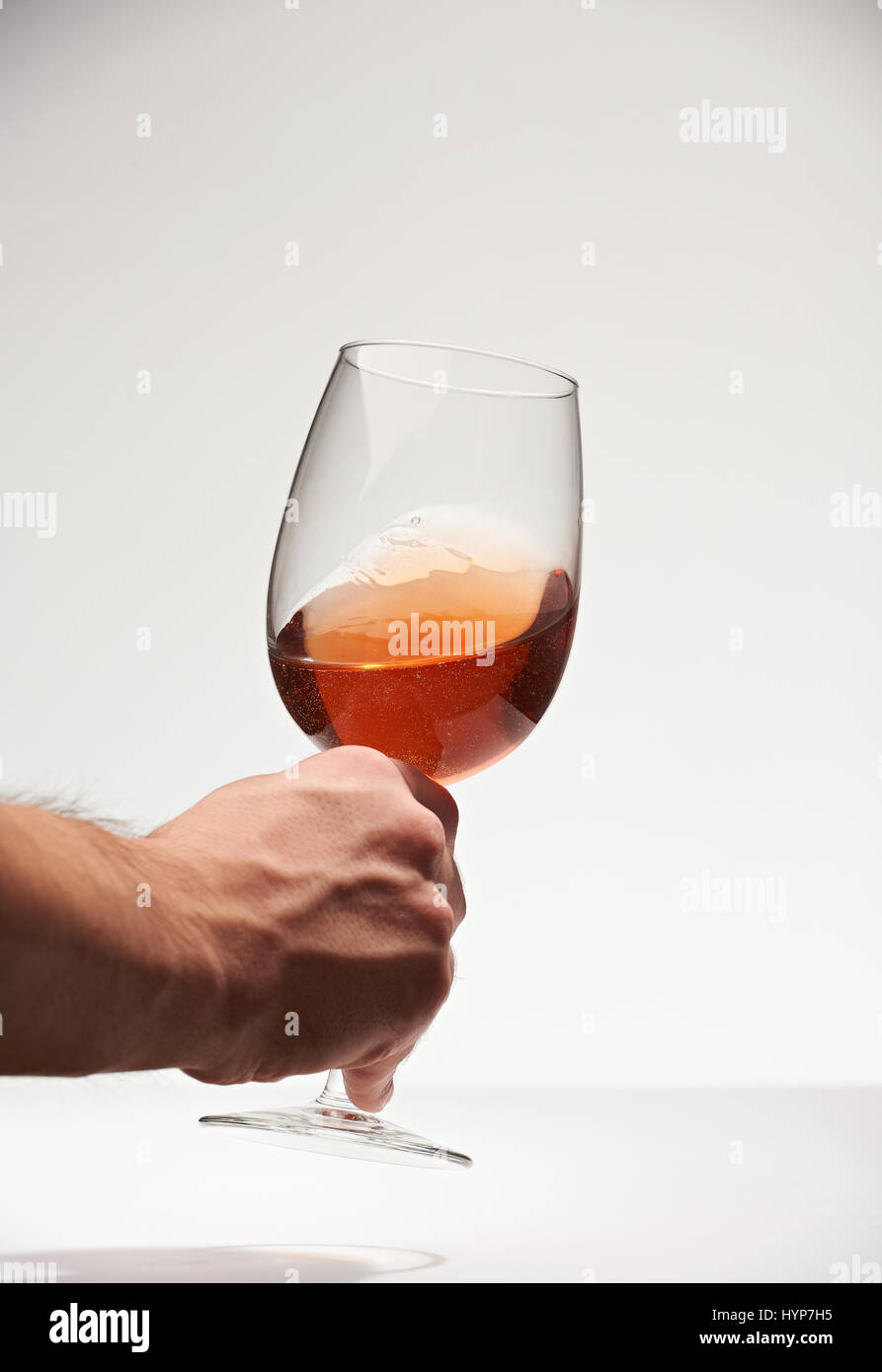 Sommelier mano con vino rosso vetro isolato su sfondo bianco. Prova del vino Foto Stock
