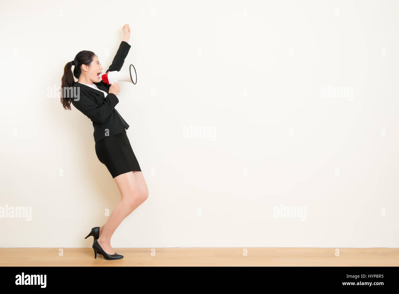 Business donna parlando in megafono con muro bianco sfondo. bella asiatica office lady. faccia emozione espressione dei sentimenti. Ultime notizie Foto Stock