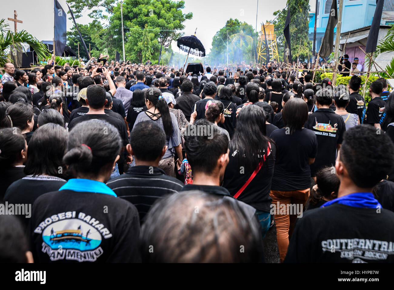 Migliaia di Cattolici Romani devoti a piedi lungo con una scatola di legno contenente la statua di Tuan Meninu (Gesù bambino) durante la le processioni della Settimana Santa. Foto Stock