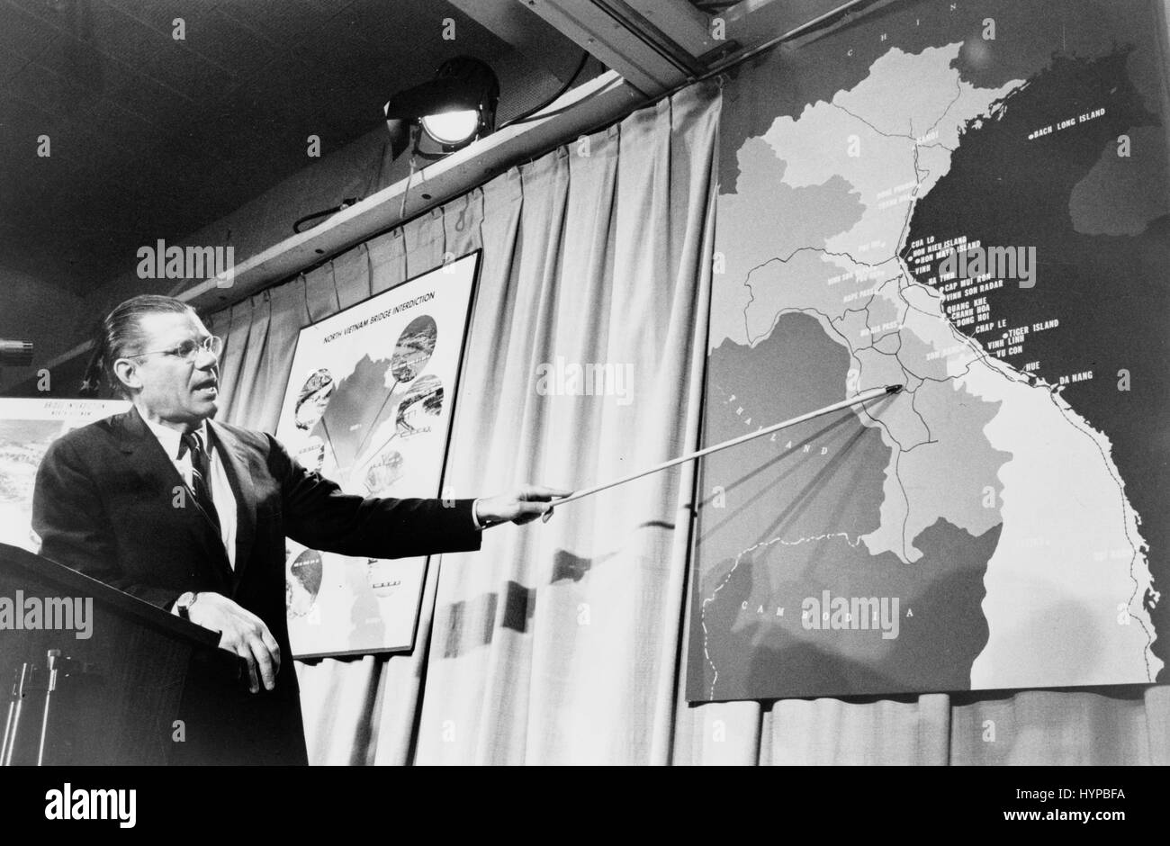 Il Segretario della Difesa Robert McNamara che puntano a una mappa del Vietnam in occasione di una conferenza stampa. Washington, DC. Aprile 26, 1965. Foto di Marion S. Trikosko. Foto Stock