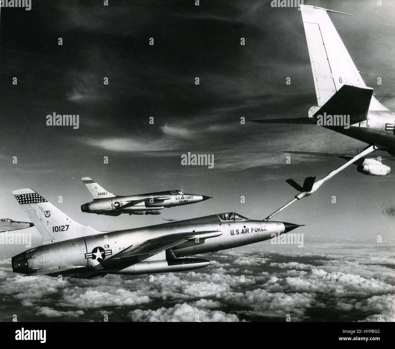 Tre Air Force F-105 Thunderchief piloti lungo il tragitto di bombardare gli obiettivi militari in Vietnam tirare fino a volare Air Force 'gas station.' Il rifornimento aereo è una Forza Aerea KC-135 Stratotanker, Vietnam, Gennaio 1966. Foto Stock