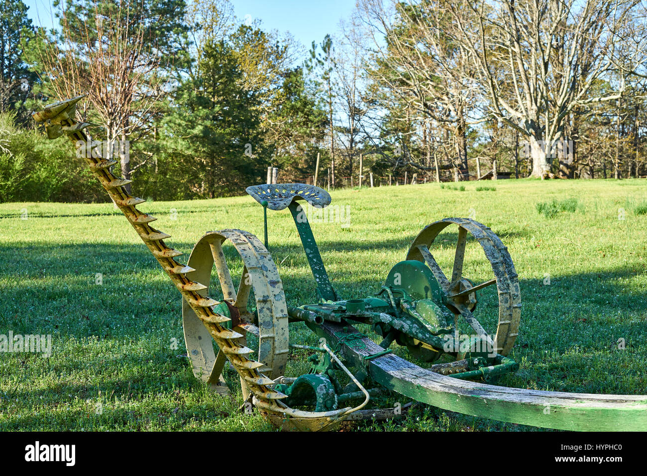 Un cavallo tirato il tosaerba riposa in un campo aperto come un promemoria dei tempi andati. Foto Stock
