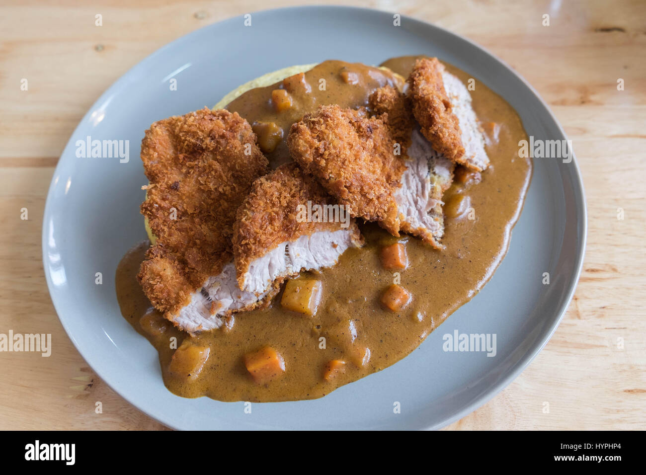 Frittata di riso con curry giapponese impanati e fritti Cotoletta di maiale sul Tavolo moderno in legno Foto Stock