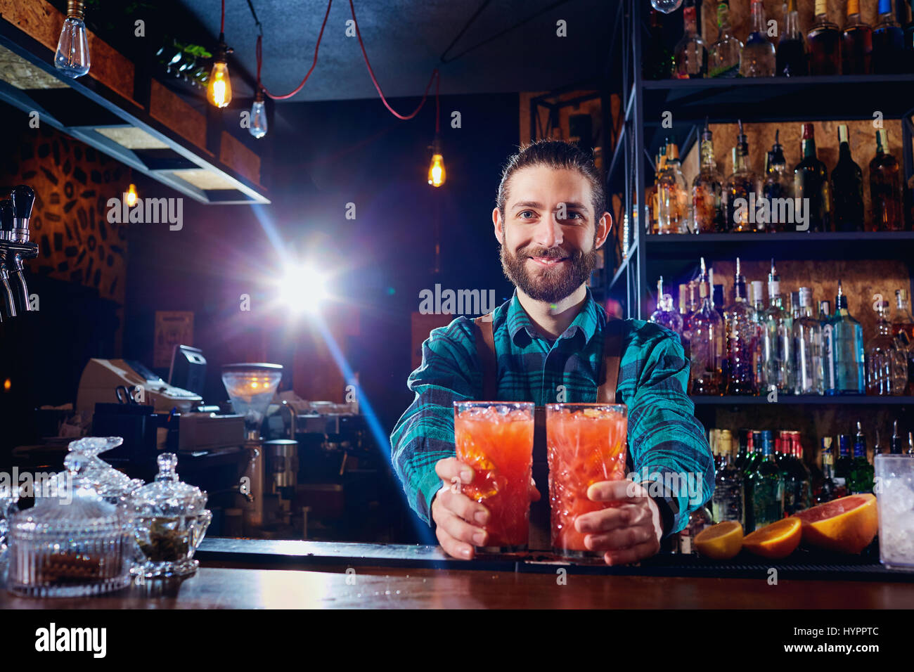 Barman tiene fuori cocktail ai client presso il bar nel ristorante. Foto Stock