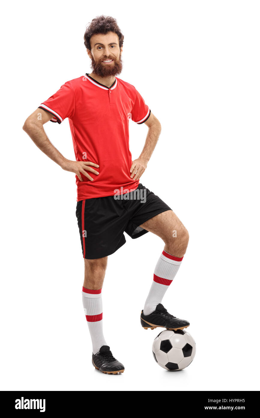 A piena lunghezza Ritratto di un ragazzo in una maglia rossa premendo un calcio con il piede isolato su sfondo bianco Foto Stock