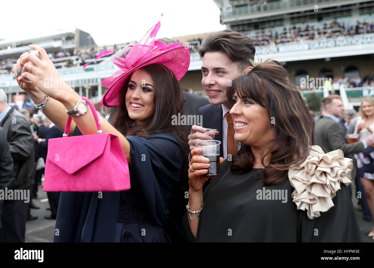 Racegoers prendere un selfie durante il giorno uno della sanità Randox Grand National Festival presso l'Aintree Racecourse. Foto Stock