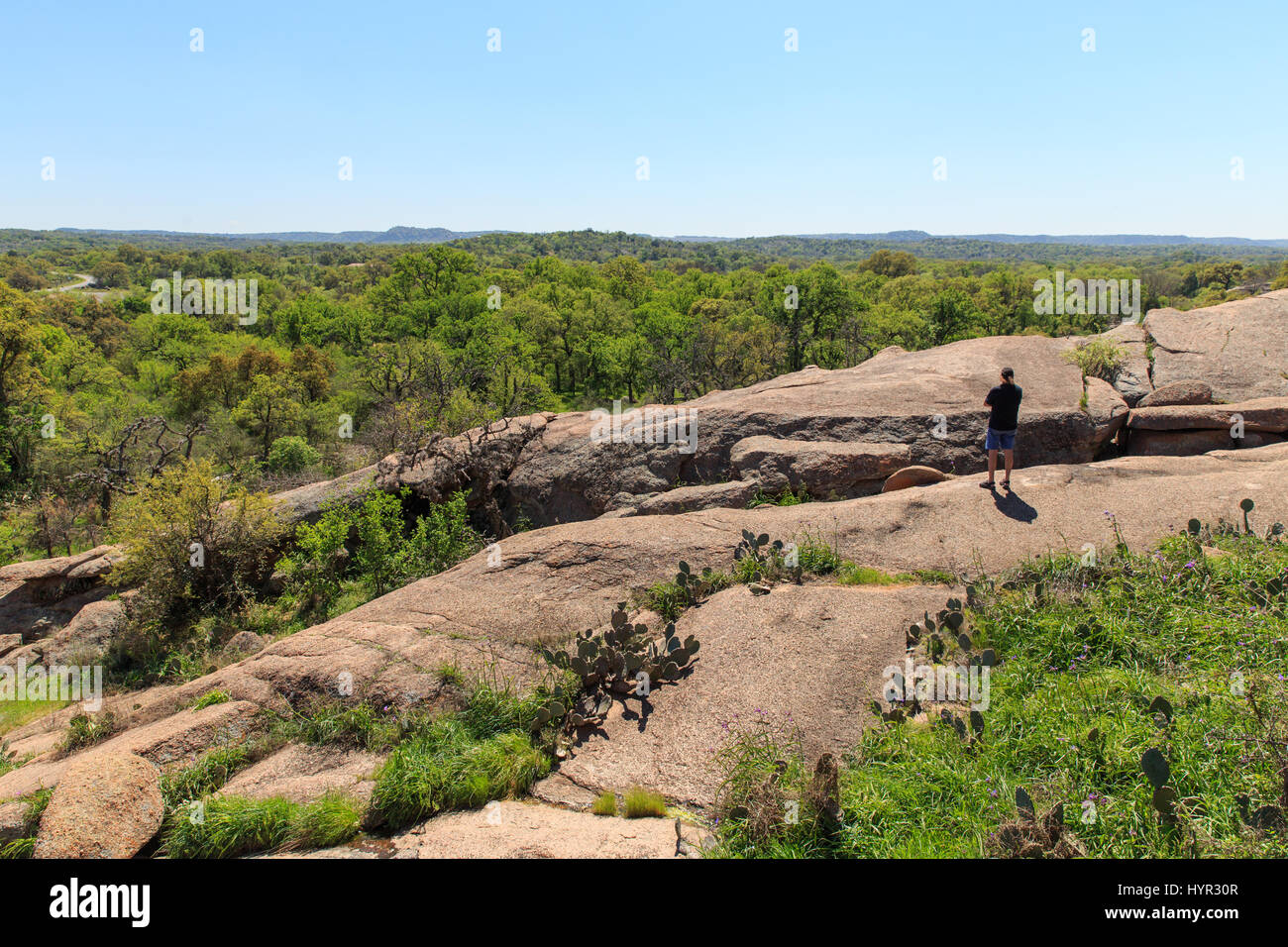 Un uomo prende nel Texas centrale vista da uno dei sentieri escursionistici in Enchanted Rock State Park, appena fuori di Fredericksburg, Texas. Foto Stock