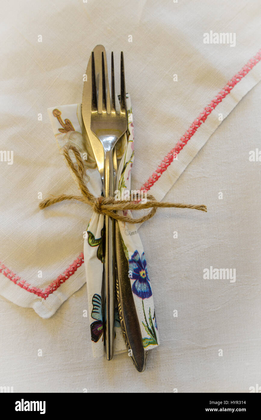 Set di posate e igienico con una stringa prua su un tavolo, impostazione per il tè del pomeriggio. Foto Stock