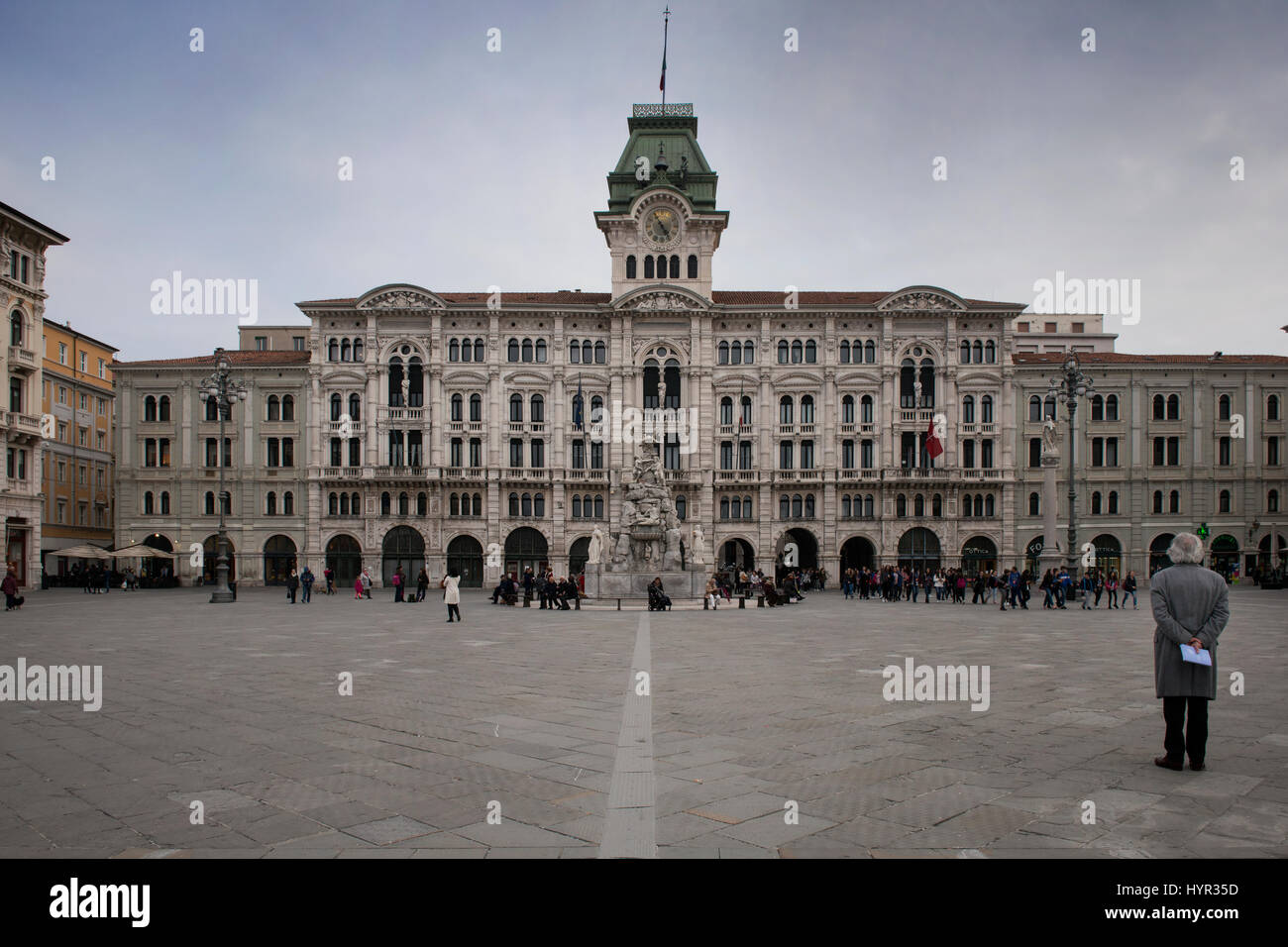 Un turista su Piazza Unità d'Italia, la piazza principale di Trieste, guardando il palazzo comunale. Trieste, Friuli Venezia Giulia, Italia. Foto Stock