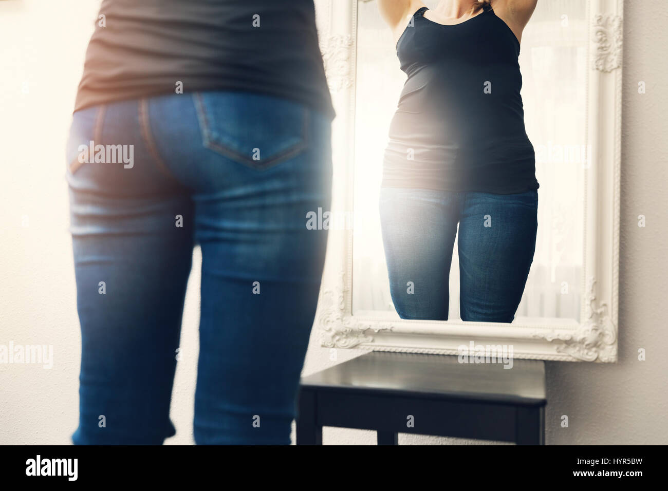 Anoressia concetto - donna guarda la sua riflessione di grasso in specchio Foto Stock