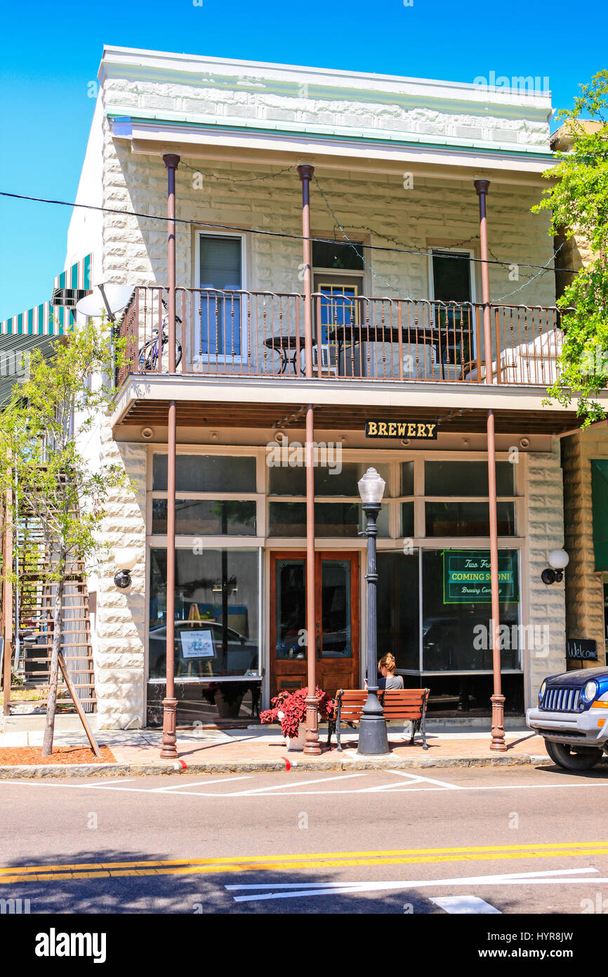 Donna seduta al di fuori di un brewpub edificio nel centro di Tarpon Springs, in Florida Foto Stock
