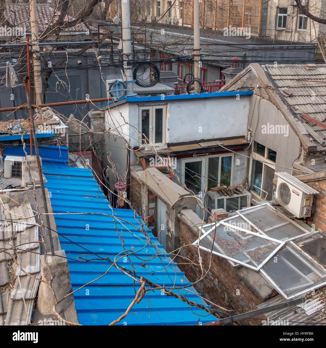 Vista delle vecchie case di cinesi e cortili con verdura al di fuori di essiccazione tradizionale con muratura in mattoni grigi e tetti blu Shijia Hutong a Pechino, Cina Foto Stock