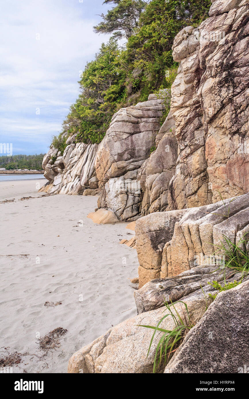 Erose scogliere di granito luogo accanto ad una spiaggia di sabbia sull'esterno esposto costa di Calvert Isola, British Columbia. Foto Stock